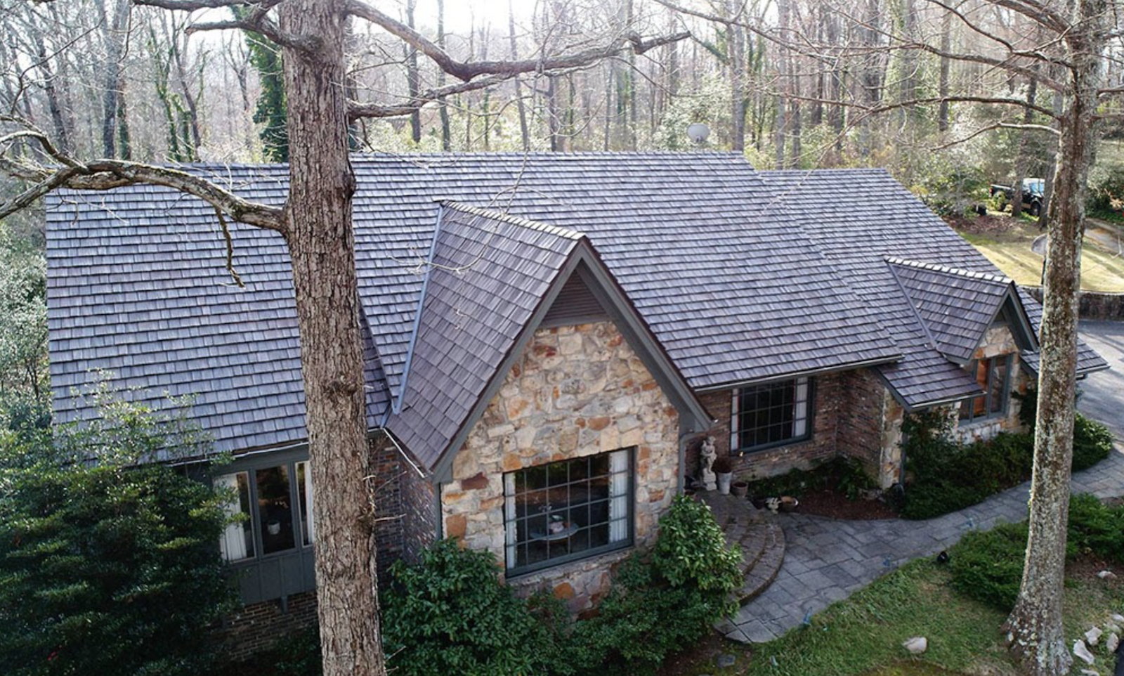 Stone Front Woodland Cottage With Brown Shake Roof